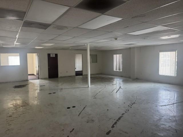 Large open office area with windows on two sides and private offices off the back